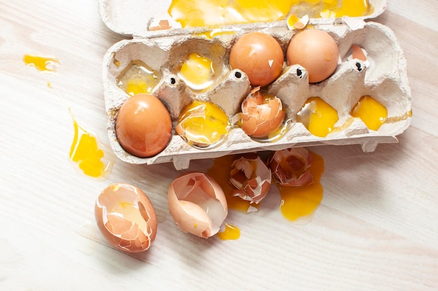 Połamane jajka w pojemniku pełnym jajek na podłodze
