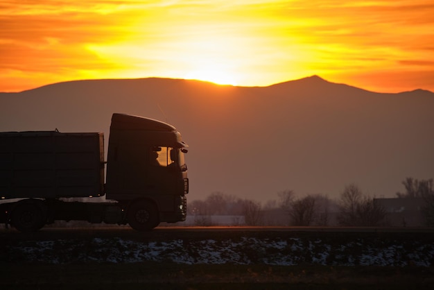 Półciężarówka z przyczepą towarową jeżdżącą po autostradzie, przewożącą towary wieczorem Dostawa koncepcja transportu i logistyki