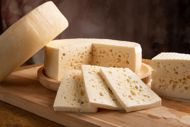 Półdojrzały ser z Brazylii, piękny brazylijski ser ułożony na jasnym rustykalnym drewnie, selektywne skupienie.