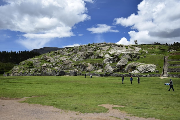 Pole z zieloną trawą przed ruinami Inków Saqsaywaman niedaleko Cusco