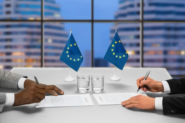 Politycy podpisują porozumienie w megalopolis. Politycy podpisują dokumenty w pobliżu okna. Wieczorne spotkanie dwóch polityków. Zawieranie porozumień w wielkiej polityce.