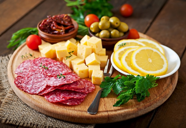 Półmisek gastronomiczny Antipasto z salami i serem na drewnianym stole