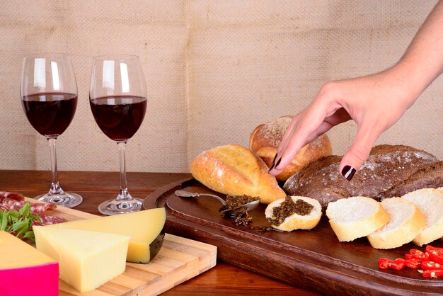 Zdjęcie półmisek wędlin i serów, chleba, chimichurri i czerwonego wina