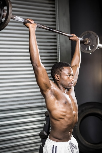 Półnagi mężczyzna podnoszenia sztangi w siłowni CrossFit