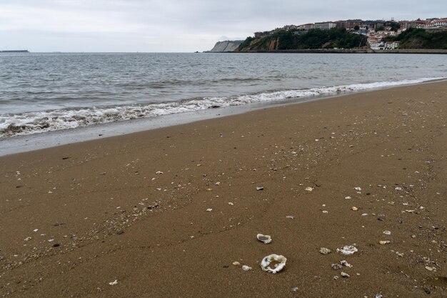 PÓŁNOCNA PLAŻA Z FALAMI I SKAŁAMI POD ZACHEMNYM WIOSENNYM NIEBEM