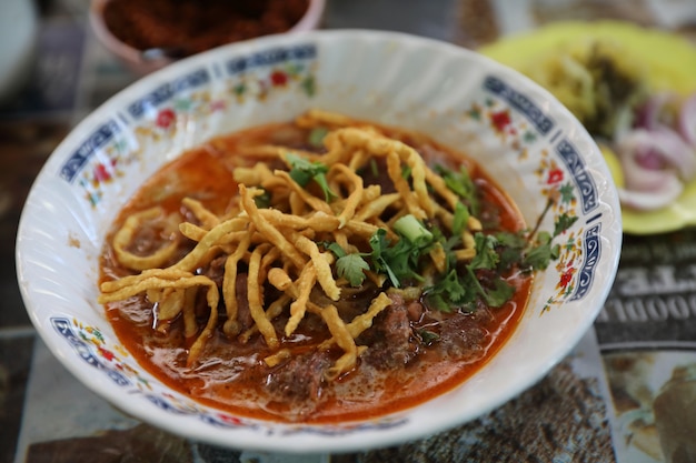 Zdjęcie północno-tajska zupa curry noodles, lokalne tajskie jedzenie uliczne khao soi