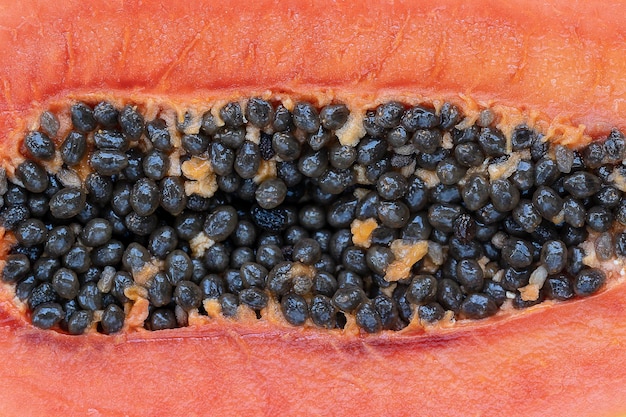 Połowa dojrzałej słodkiej papai z zbliżeniem tła nasion