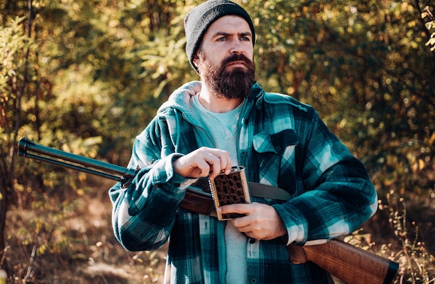 Polowanie w Rosji łowca z strzelbą na polowaniu portret przystojniaka łowcy jesienią