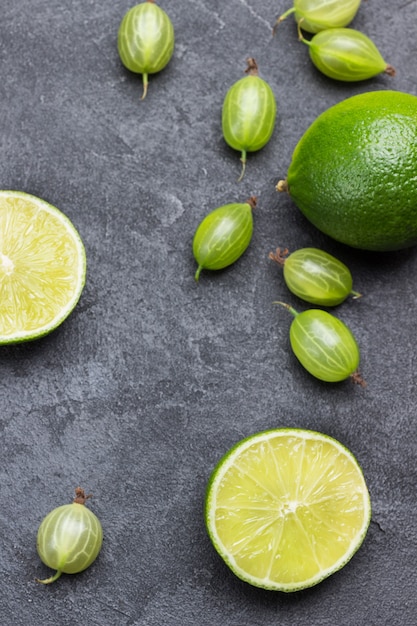 Połówki limonki i jagody agrestu na czarnym tle. Widok z góry