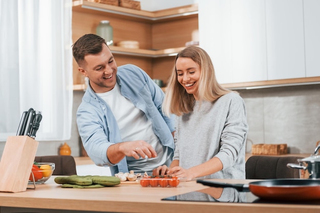 Pomaganie sobie nawzajem Para przygotowująca jedzenie w domu w nowoczesnej kuchni