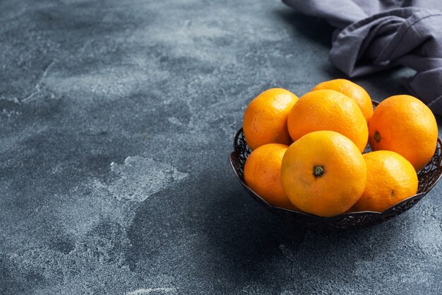 Zdjęcie pomarańcze mandarynki lub mandarynki klementynki, owoce cytrusowe na ciemnym stole.