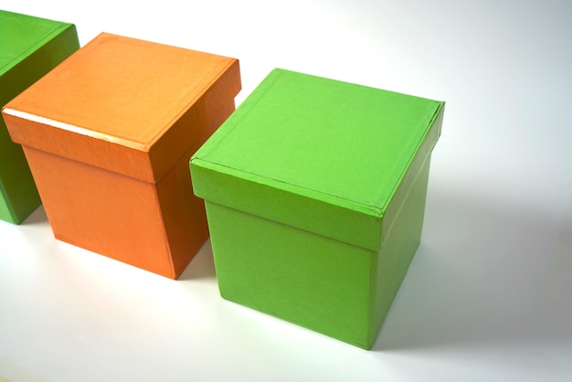 Pomarańczowe i zielone kartonowe pudełka na prezent na białym, odizolowanym tle