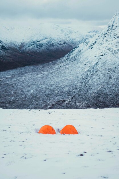 Pomarańczowe namioty na zaśnieżonej górze