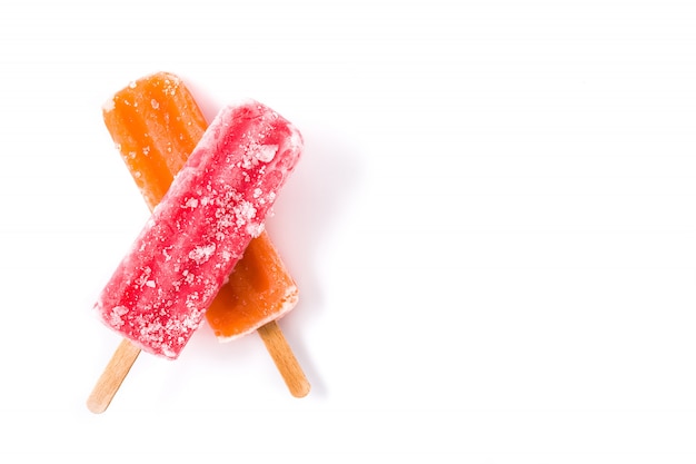 Pomarańczowi i truskawkowi popsicles odizolowywający na biel kopii przestrzeni