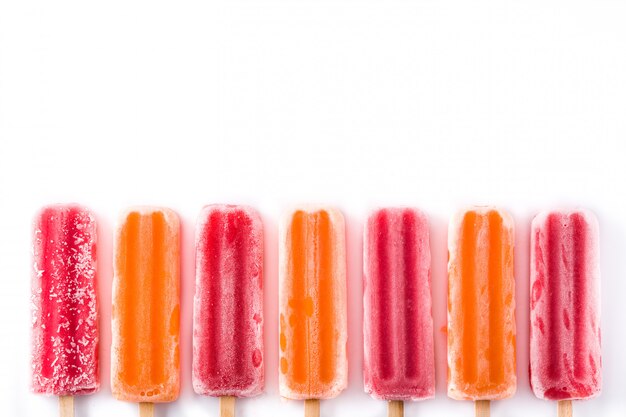 Pomarańczowi i truskawkowi popsicles odizolowywający na bielu