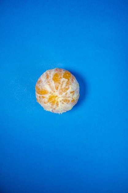 Pomarańczowy bez skórki na niebieskim tle widok z góry