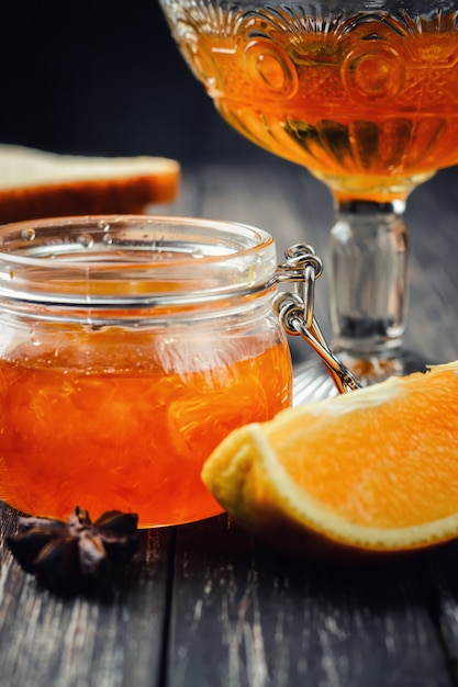 Pomarańczowy dżem w szklanym słoju na ciemnym tle