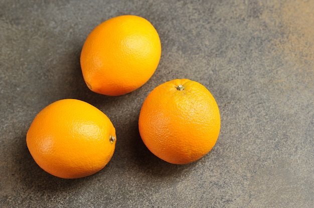 Pomarańczowy kolor dojrzałych pomarańczy na szarym tle