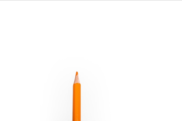 Pomarańczowy ołówek na białym tle kopii przestrzeni