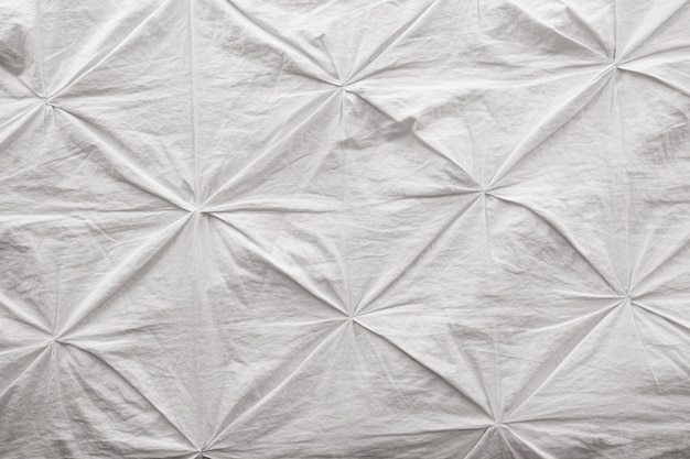 Pomarszczona biała tkanina z dekoracyjnymi szczypcami pościel i tekstylia we wnętrzu powierzchnia tekstylna kopia przestrzeń