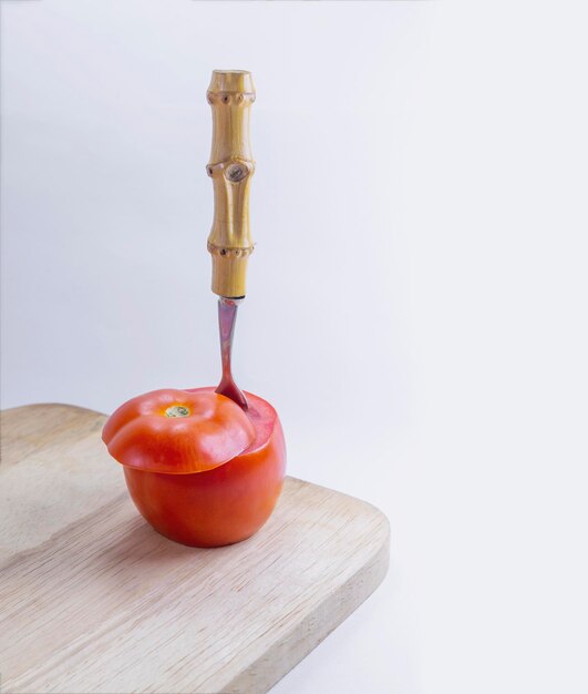 Zdjęcie pomidor na desce do cięcia na białym tle
