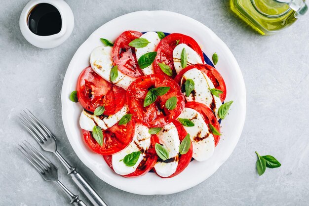 Pomidorowa bazylia mozzarella Sałatka Caprese z octem balsamicznym i oliwą z oliwek Widok z góry szare kamienne tło