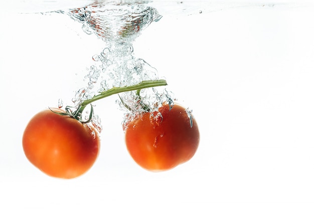 Pomidory spadają do wody z odrobiną