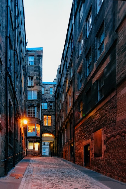 Pomiędzy starymi budynkami na ulicy Edynburga w Szkocji w Wielkiej Brytanii. Późnym wieczorem