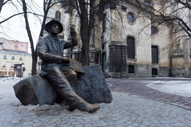 Pomnik na tle starego budynku architektonicznego we Lwowie. Ukraina