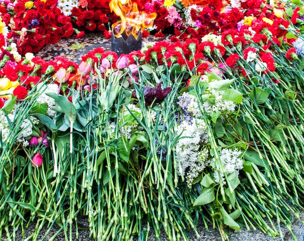 Pomnik wiecznego ognia z kwiatami w dniu zwycięstwa 9 maja II wojny światowej