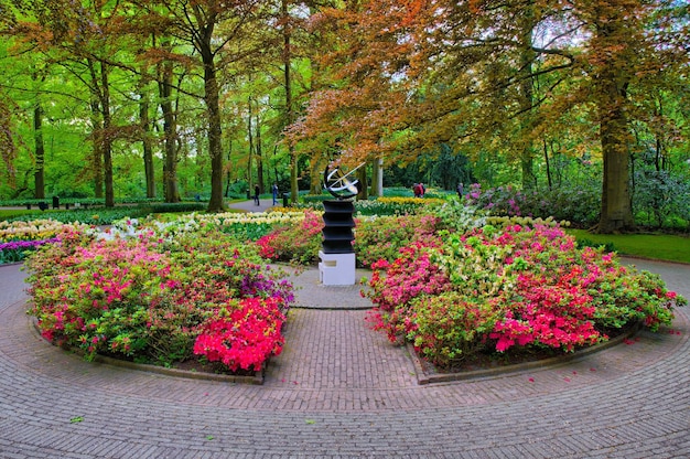 Pomnik wśród różowych kwiatów Keukenhof Park Lisse w Holandii