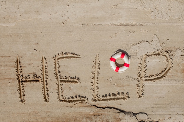 Pomoc napis na piasku z boją pierścieniową
