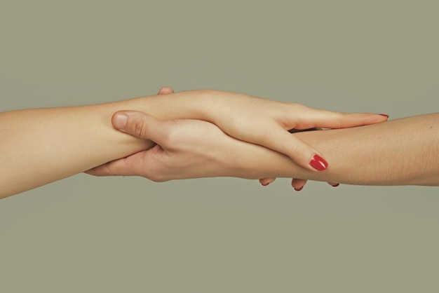Pomocna dłoń trzymająca dłoń z bliska, podająca pomocną dłoń na ratunek, pomagający gest lub zbawienie rąk r