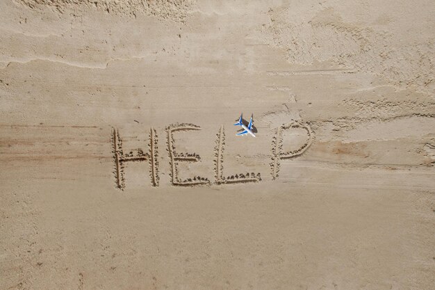 Pomóż mi napis na piasku Proszę pomóż mi Na tropikalnej plaży