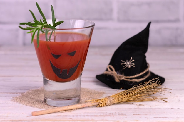 Zdjęcie pomysł na drinka na halloween. freak potwór koktajl soku pomidorowego. jack-o-lantern twarz na szkle.