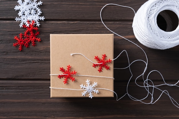 Pomysł na prezenty jako opakowanie prezentu świątecznego i dekoracji z ozdobnymi czerwono-białymi płatkami śniegu. Naturalny design. Pakowanie prezentów świątecznych. Krok po kroku