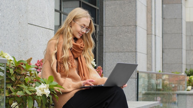 Pomyślna atrakcyjna biznesowa kobieta pracuje na laptopie w mieście kaukaskiej dziewczyny studenckiej elearning
