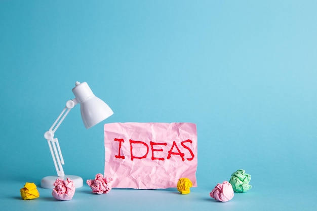 Pomysły koncepcji kreatywności z papierową zmiętą kulką i lampą