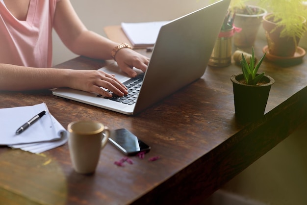 Pomysły płyną Przycięte zdjęcie kobiety pracującej na laptopie z długopisem i notatnikiem obok niej