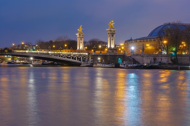Pont alexandre iii lub most alexander iii w nocy oświetlenie w paryżu we francji