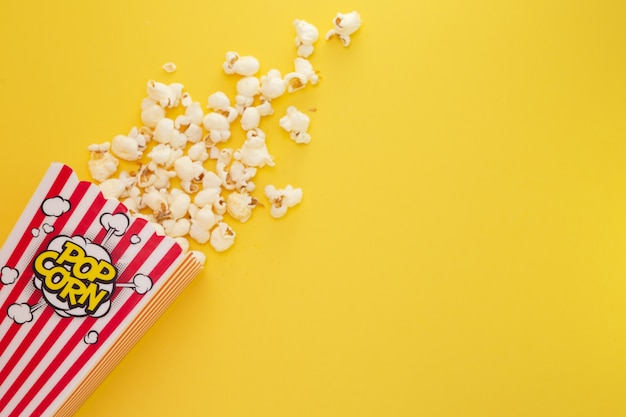 Popcorn maślany w czerwonej filiżance popcornu, przekąska w domu lub w kinie