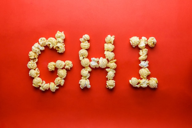 Zdjęcie popcorn tworząc literę g, h, i na czerwonym tle