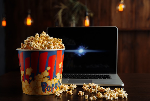 Popcorn w misce i laptop odtwarzający film.