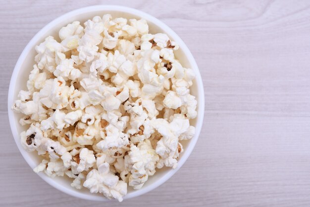 Popcorn w misce na czerwonym tle. Ścieśniać. Widok z góry.