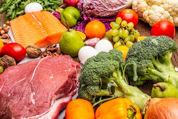Popularna dieta paleo / pegan. Koncepcja zdrowej żywności zrównoważonej. Zestaw świeżych produktów, surowego mięsa, łososia, warzyw i owoców