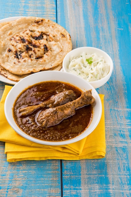 Popularne Czerwonawe Curry Z Kurczaka Lub Masala, Z Wyraźnym Kawałkiem Nogi, Podawane W Misce Z Ryżem Pilau, Chapati Lub Roti I Sałatką