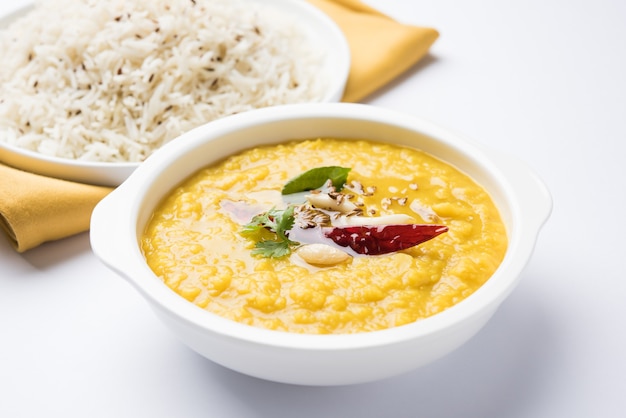 Popularne indyjskie jedzenie Dal fry lub tradycyjne Dal Tadka Curry podawane z ryżem jeera, odizolowane na białym tle, selektywne focus