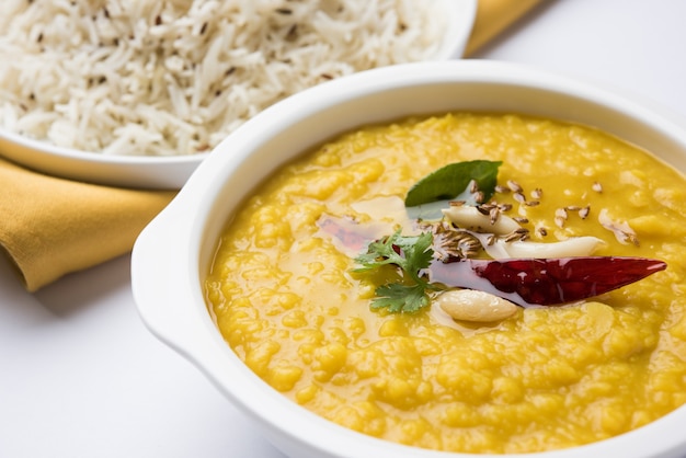 Popularne indyjskie jedzenie Dal fry lub tradycyjne Dal Tadka Curry podawane z ryżem jeera, odizolowane na białym tle, selektywne focus