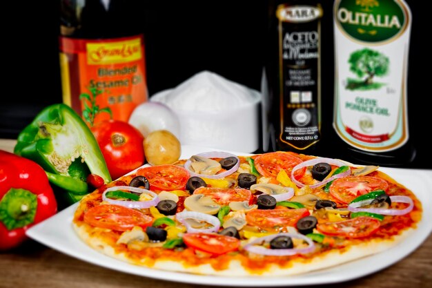 Zdjęcie popularne kolorowe składniki, takie jak pomidory, ser, grzyby, papryka, oliwki i inne składniki pieczone zdrowej pizzy