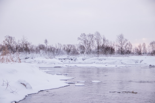 Poranny świt nad rzeką. Różowe niebo. Zimowy krajobraz